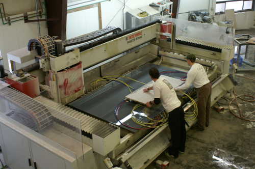 Fabricators cutting granite countertop on CNC machine